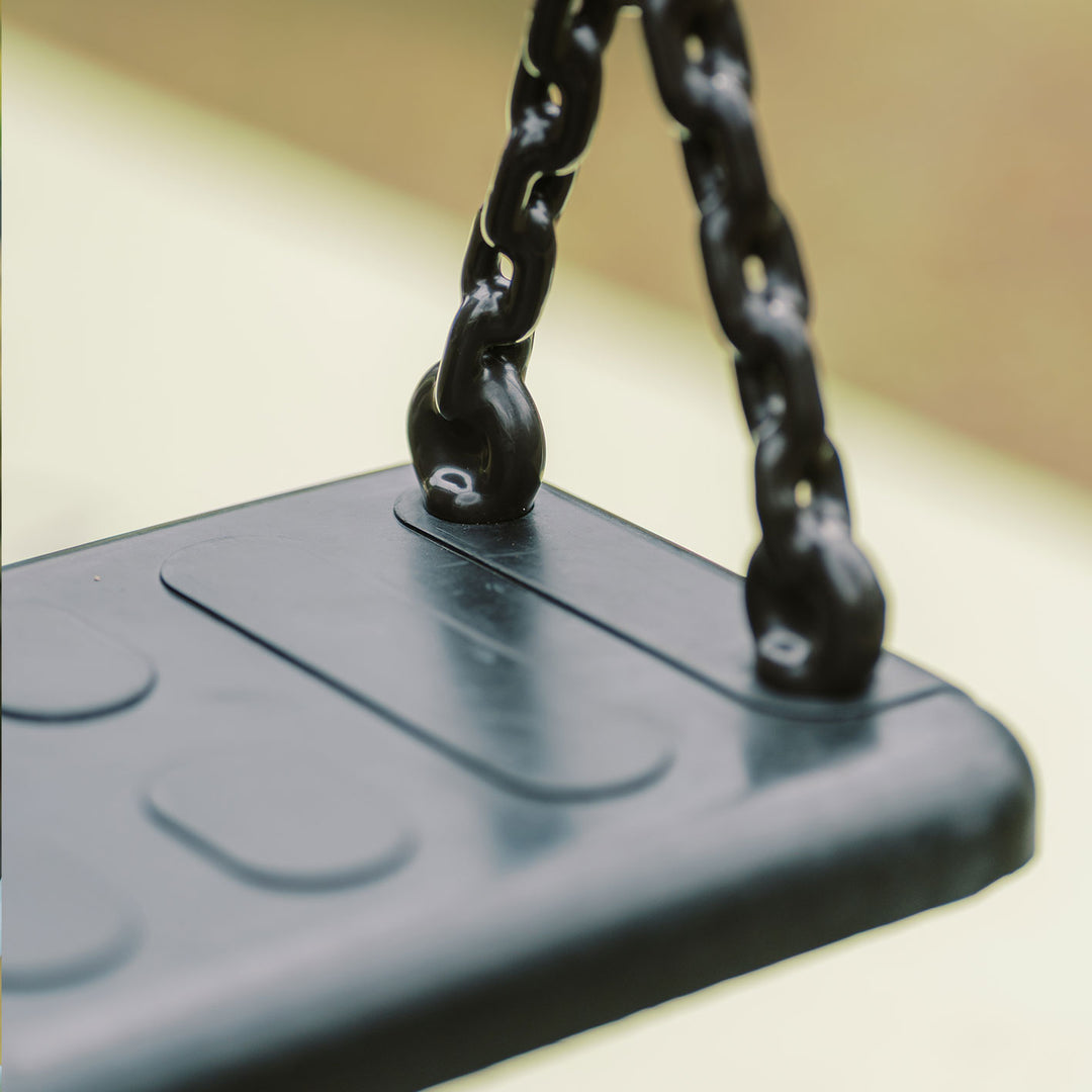 Close-up of black rubber swing seat and chain connection